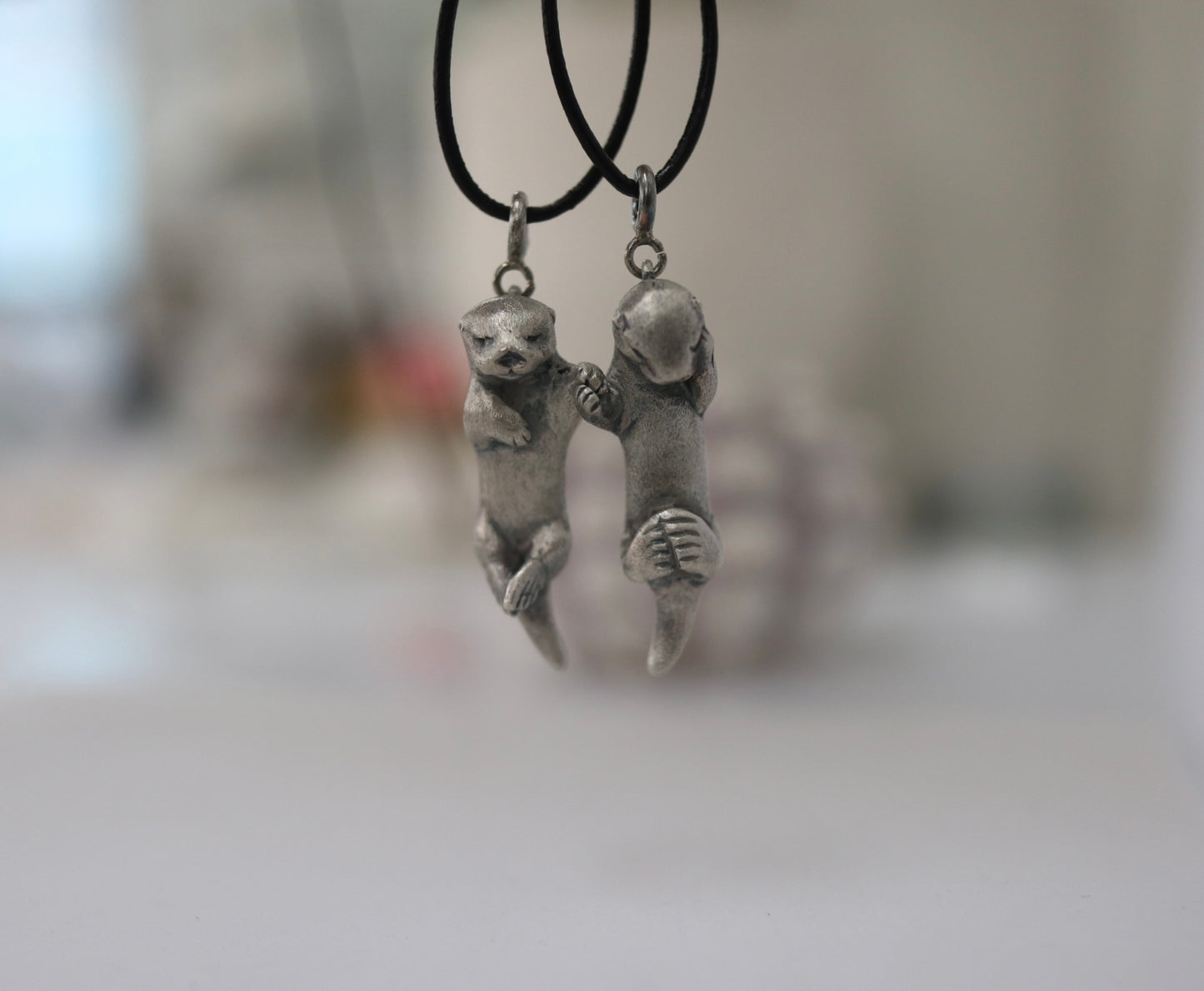 A Pair of Sea Otters Holding Hands Sterling Silver Pendants / Necklaces